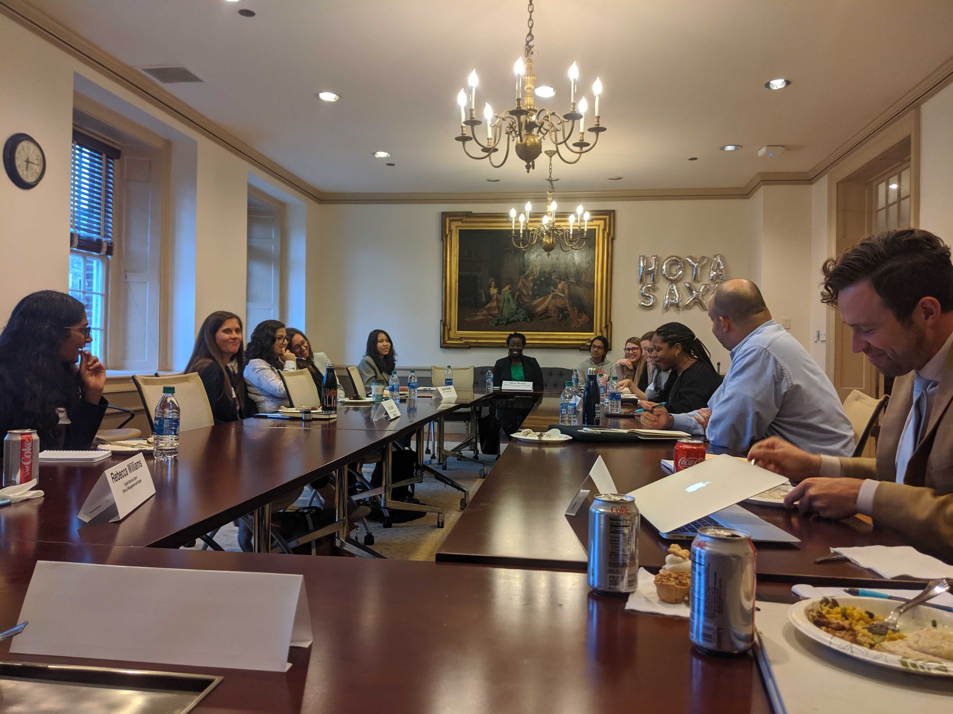 Students sit around a conference table