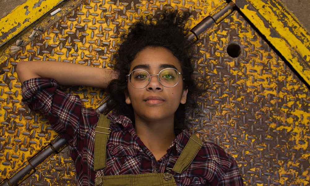 woman in glasses lies down on yellow steel platform