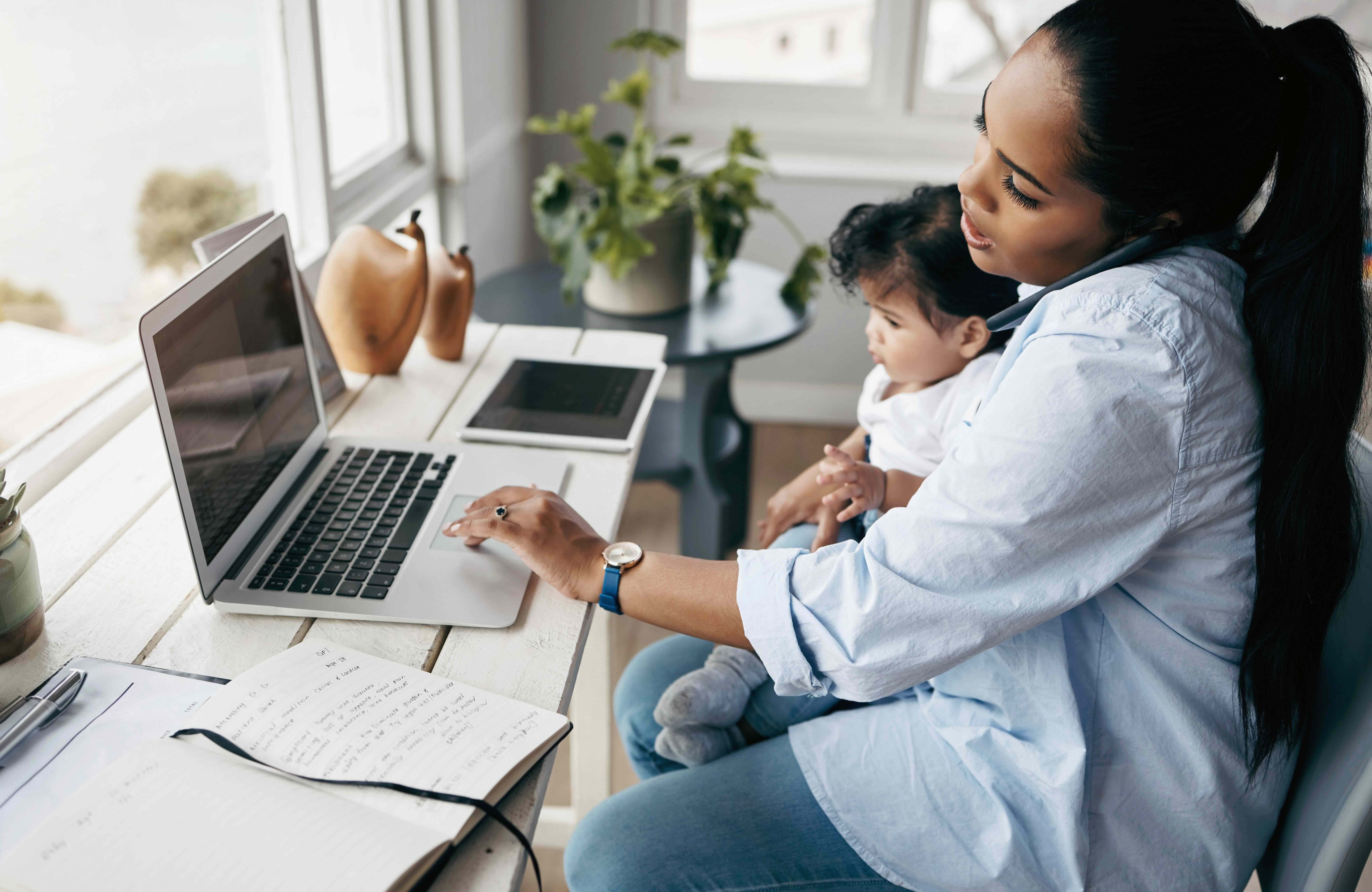 Shot of a young mother caring for her baby girl while working from home.