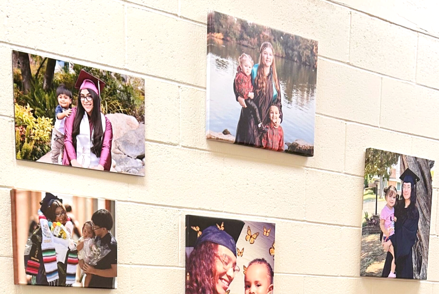 A wall displaying framed photographs of young parents and their children at Shine Together in Fresno, California.